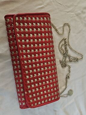 Big Buddah red and gold woven clutch bag with a detachable chain strap.